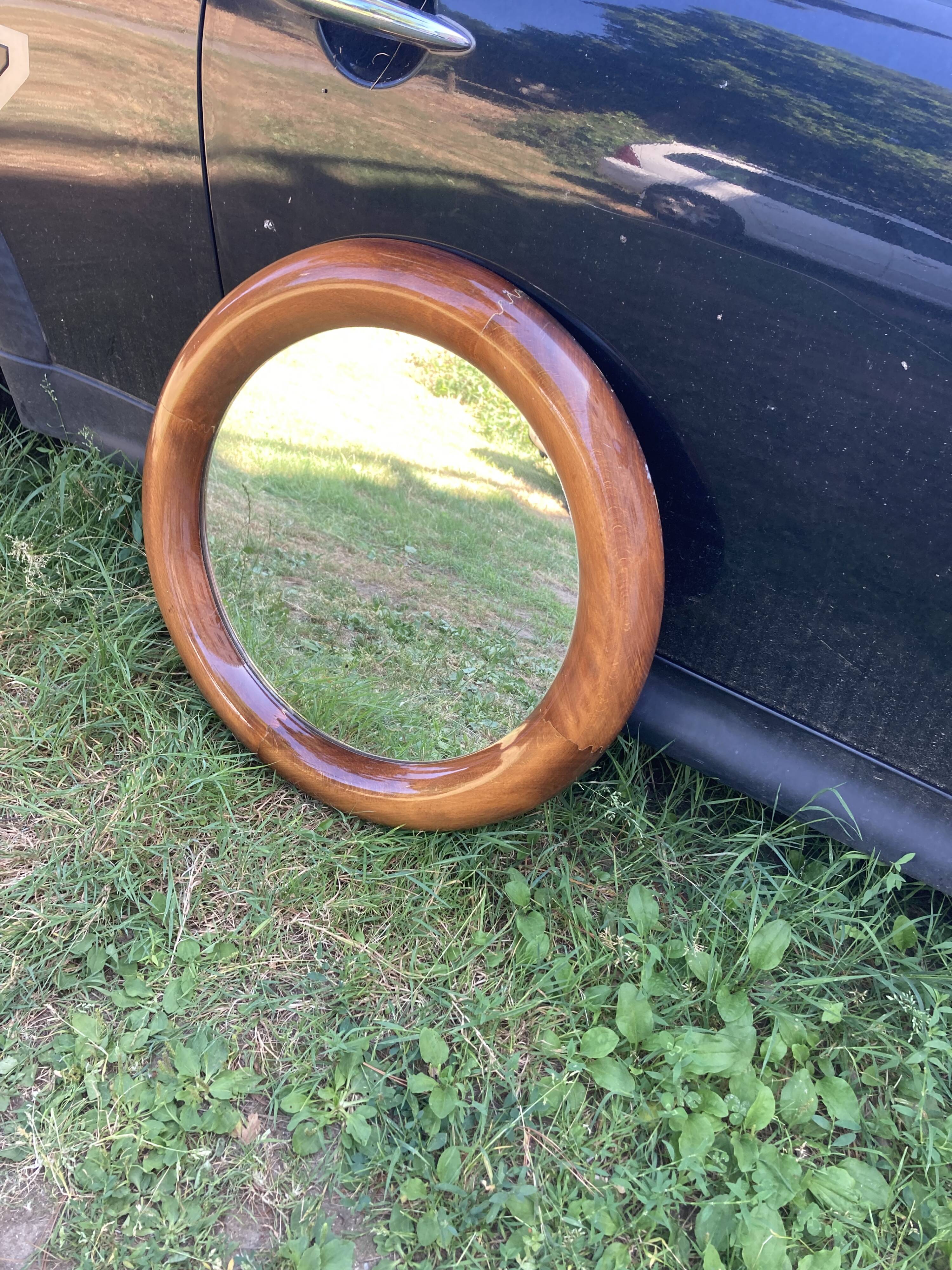 Round varnished wooden mirror