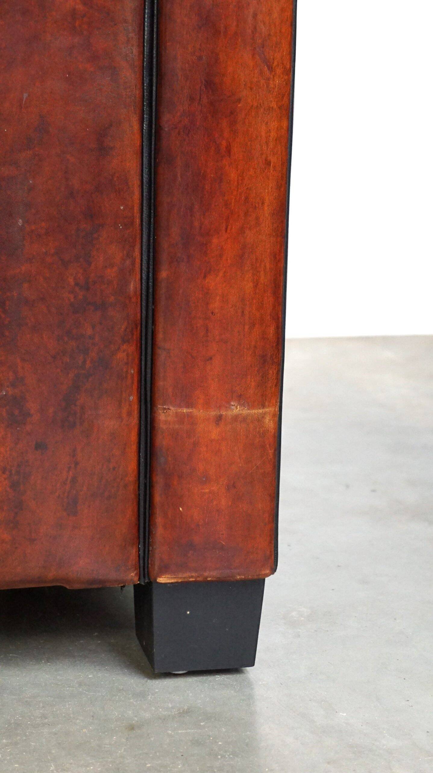 Canapé en cuir de mouton 2,5 places, luxueux et confortable, avec des coussins en tissu.