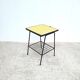 Small vintage yellow side table with magazine rack.