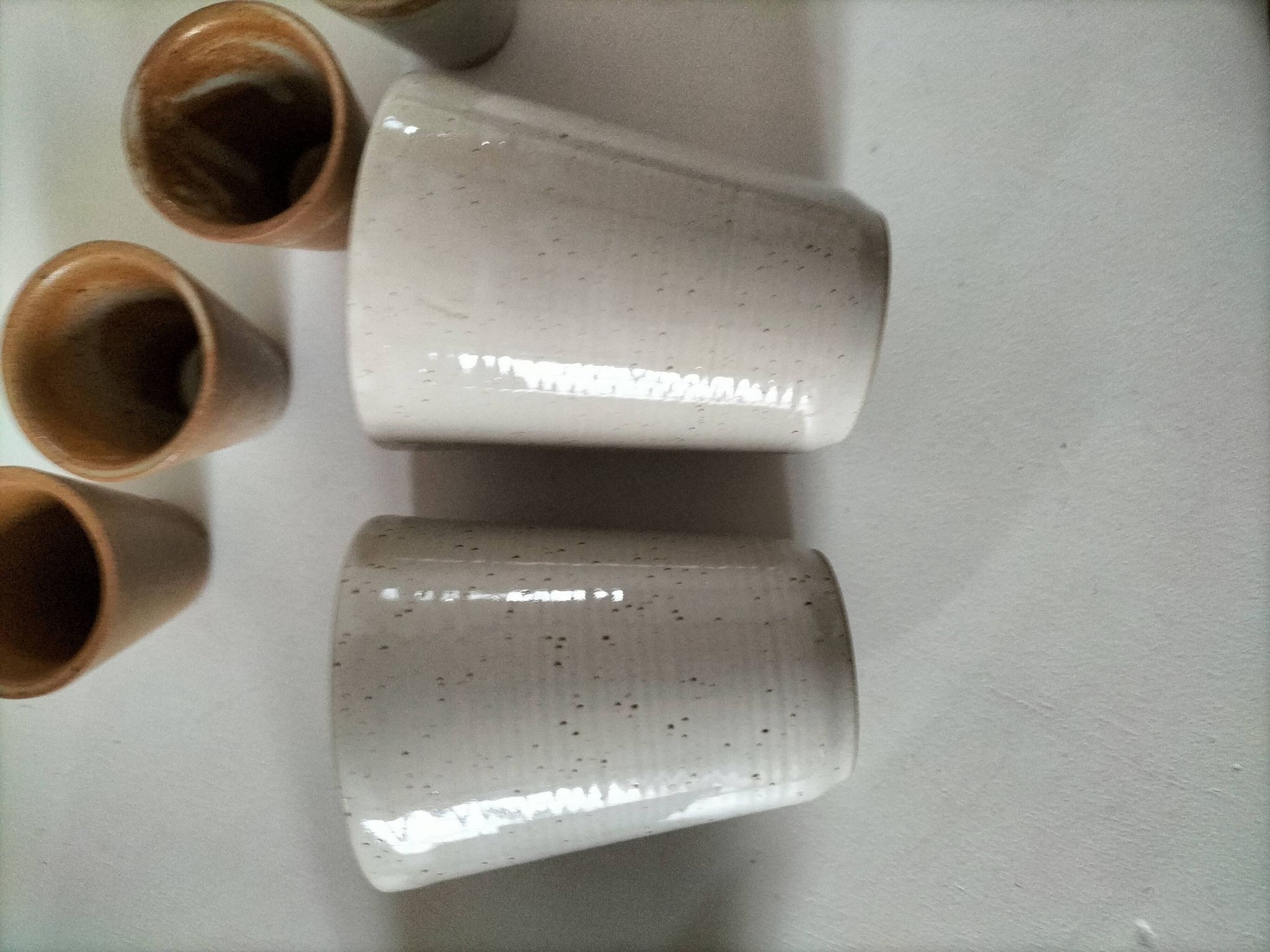 Set of 8 stoneware cups and a mug, shades of beige.