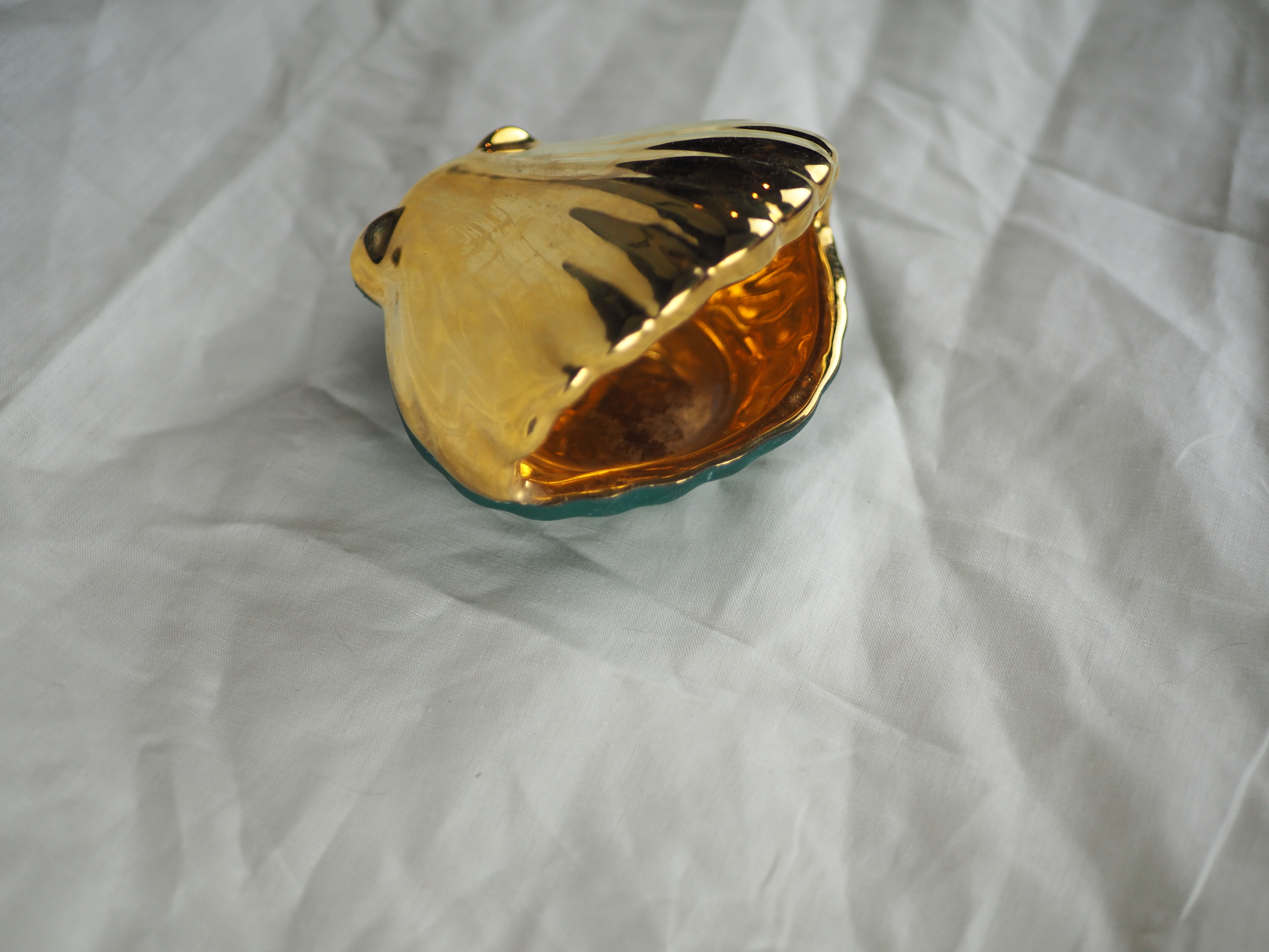 Porcelain pocket tray in the shape of a golden scallop shell with duck green background from the 50s/60s