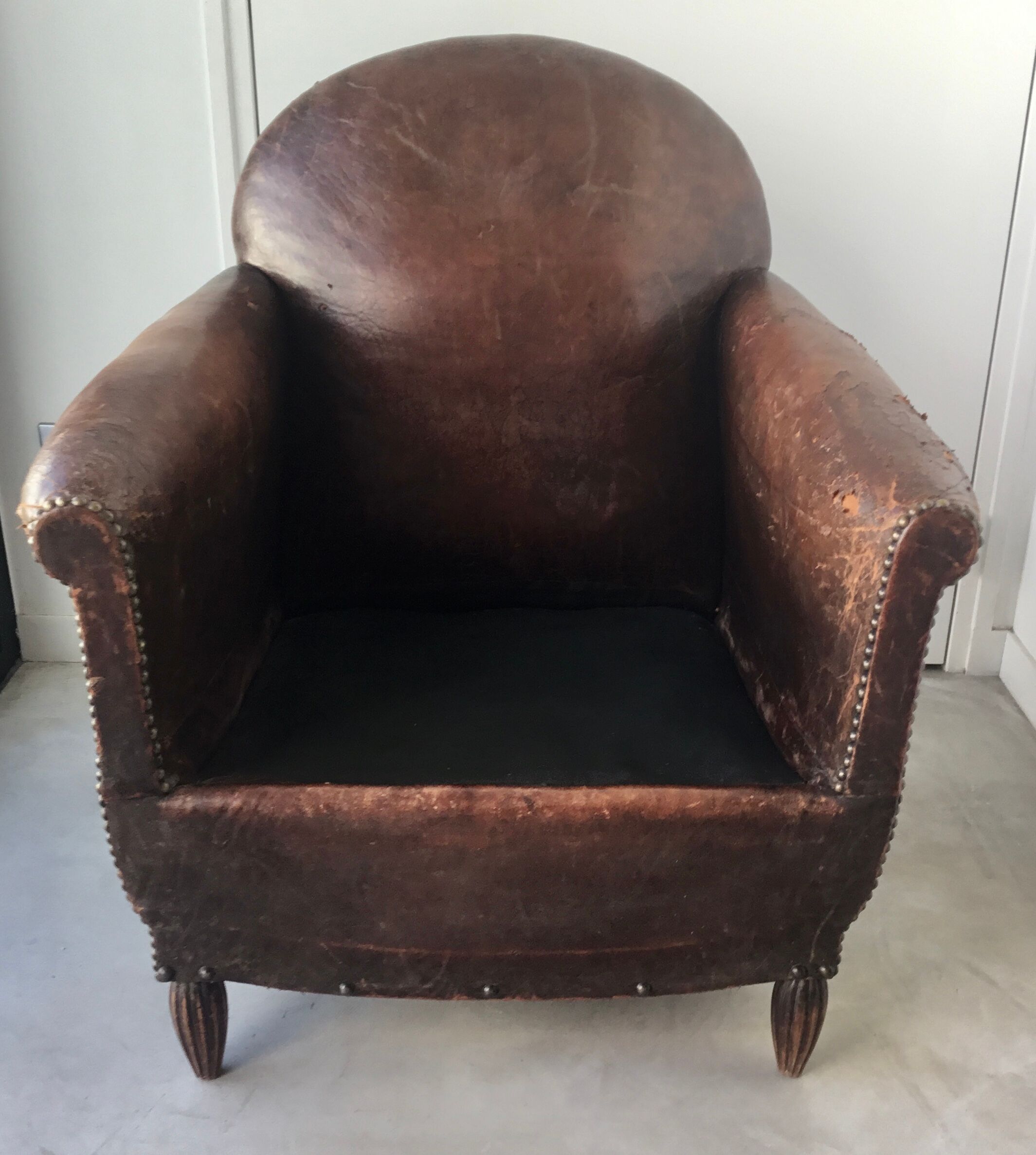 Club armchair in studded leather - early twentieth century
