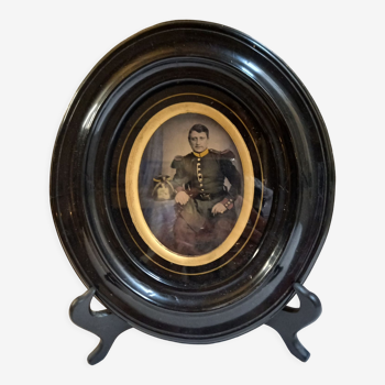 Old photograph recolorized of a soldier, under glass, painted wood frame, black and gold