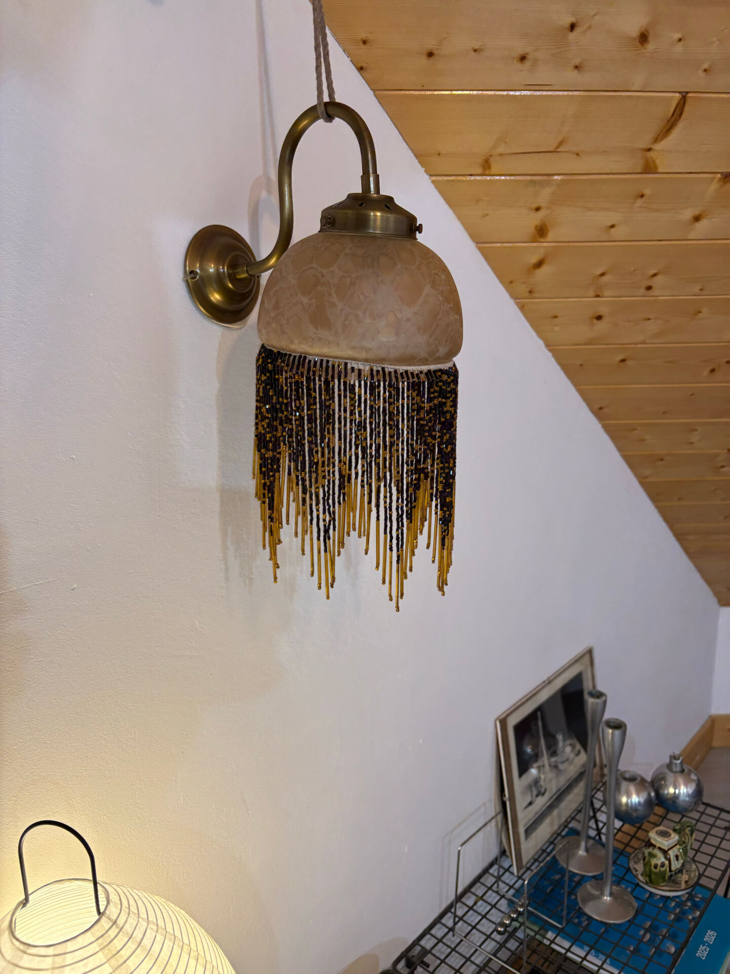 Wall lamp with marbled glass shade and beaded fringe in Art Nouveau style.