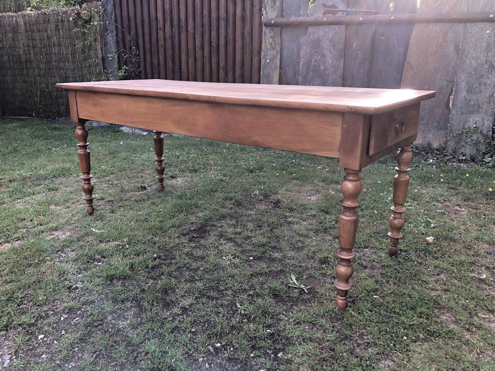 Antique farmhouse table in solid cherry wood with 2 drawers and 1 pull-out at the end with turned legs.