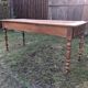 Antique farmhouse table in solid cherry wood with 2 drawers and 1 pull-out at the end with turned legs.