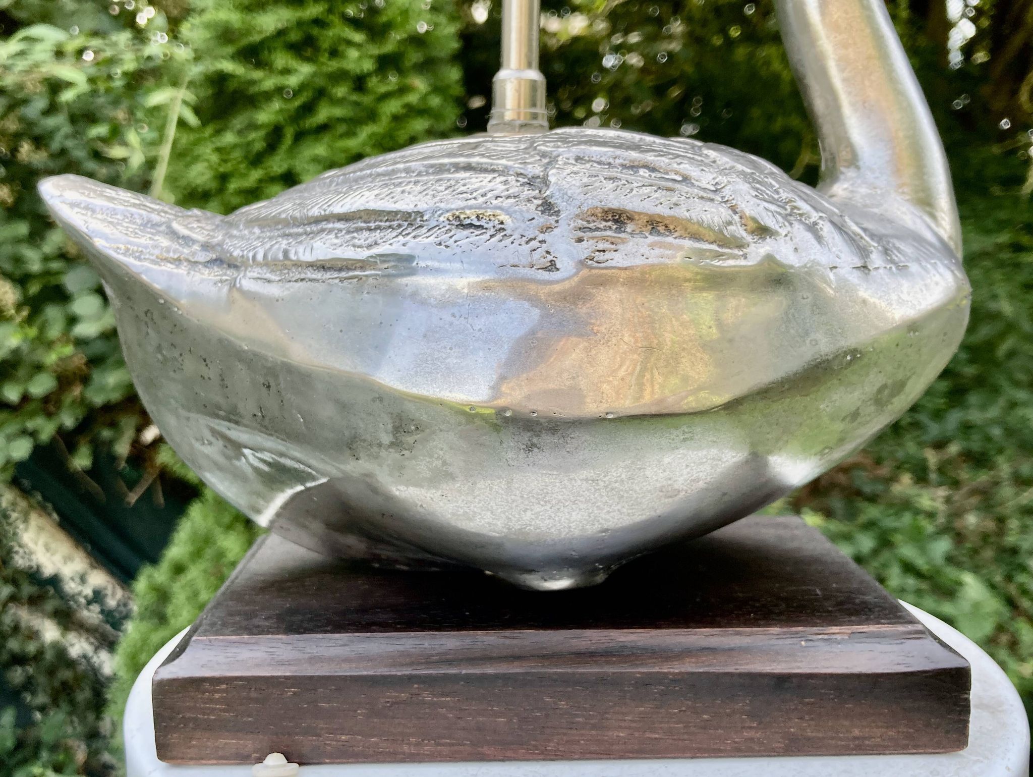 Old vintage lamp representing a duck in silver metal with wooden base