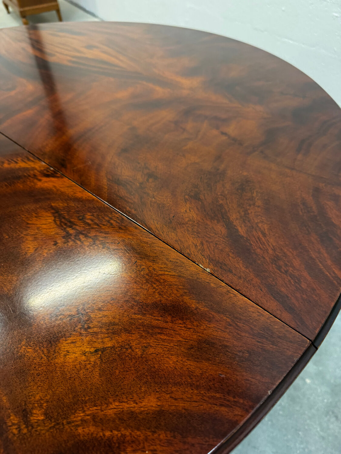 Extendable mahogany round table in Louis XVI style