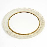 Mid Century Modern round wall mirror with a white expanded metal frame