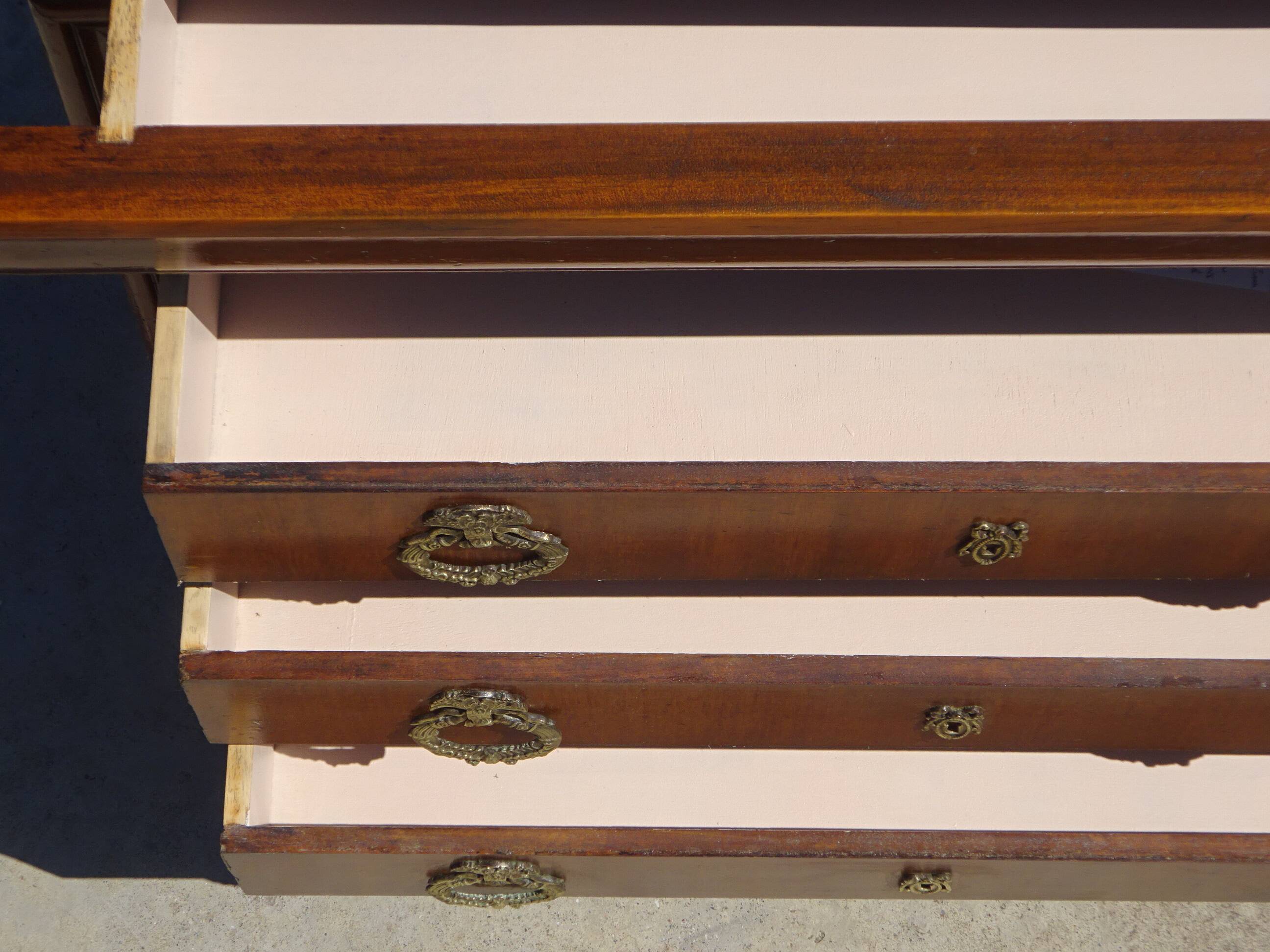 Chest of drawers with decorated handles in the Louis XVI style.