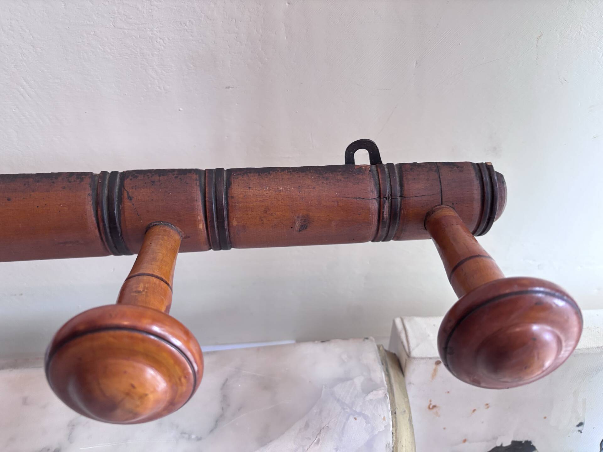 Wall-mounted coat rack with 8 turned wooden hooks in faux bamboo style.