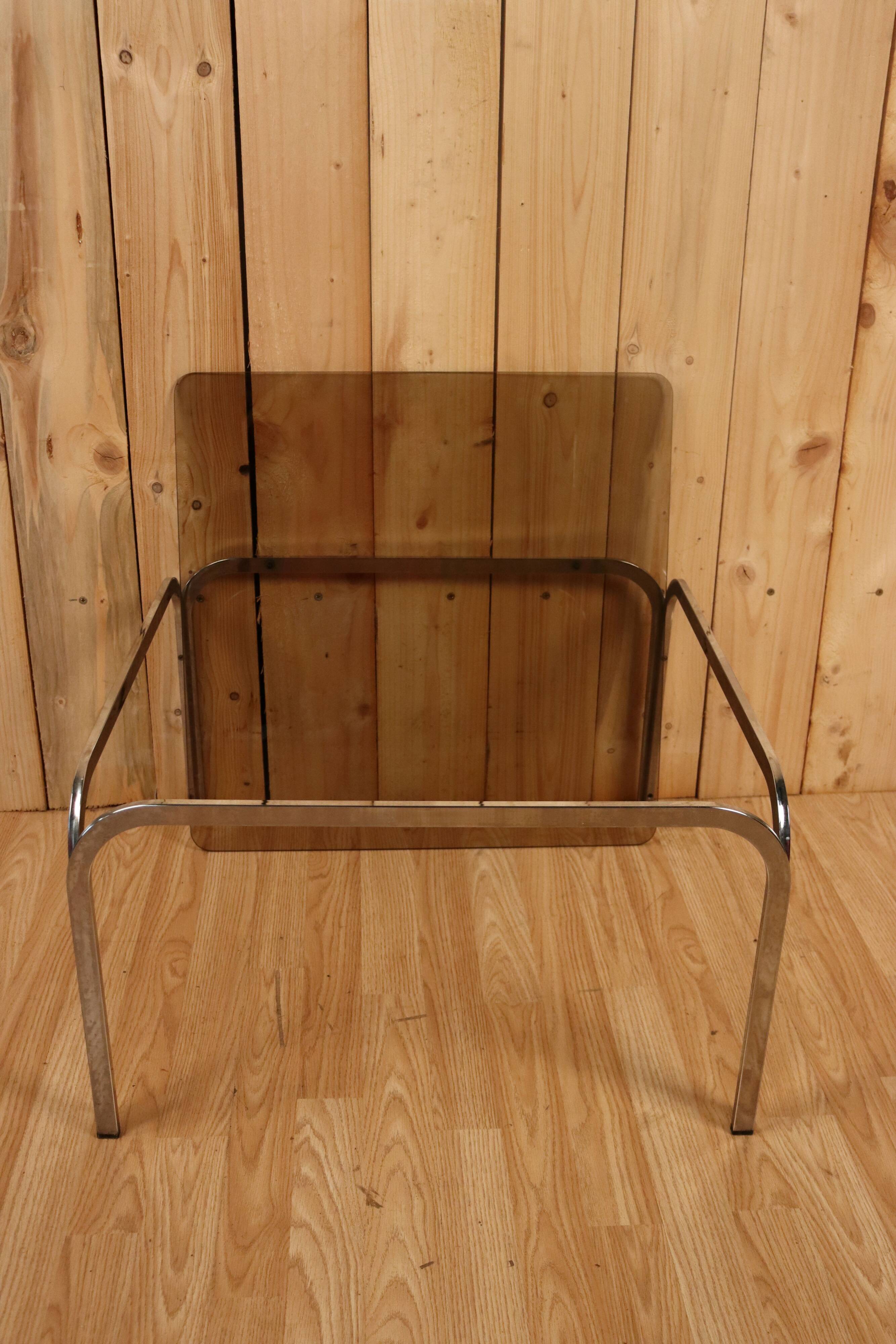 Table basse verre fumé et acier tubulaire.
