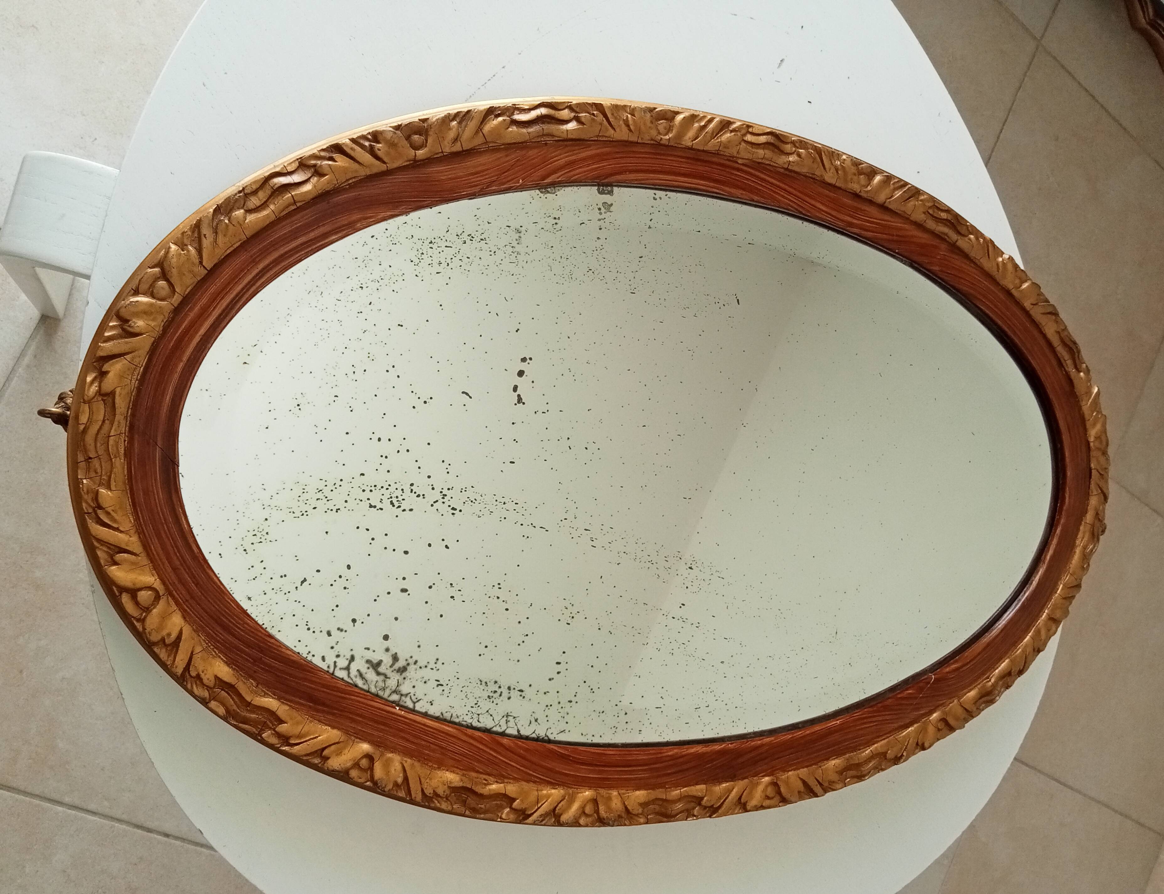 Antique oval mirror with beveled glass in wood and stucco, 19th century