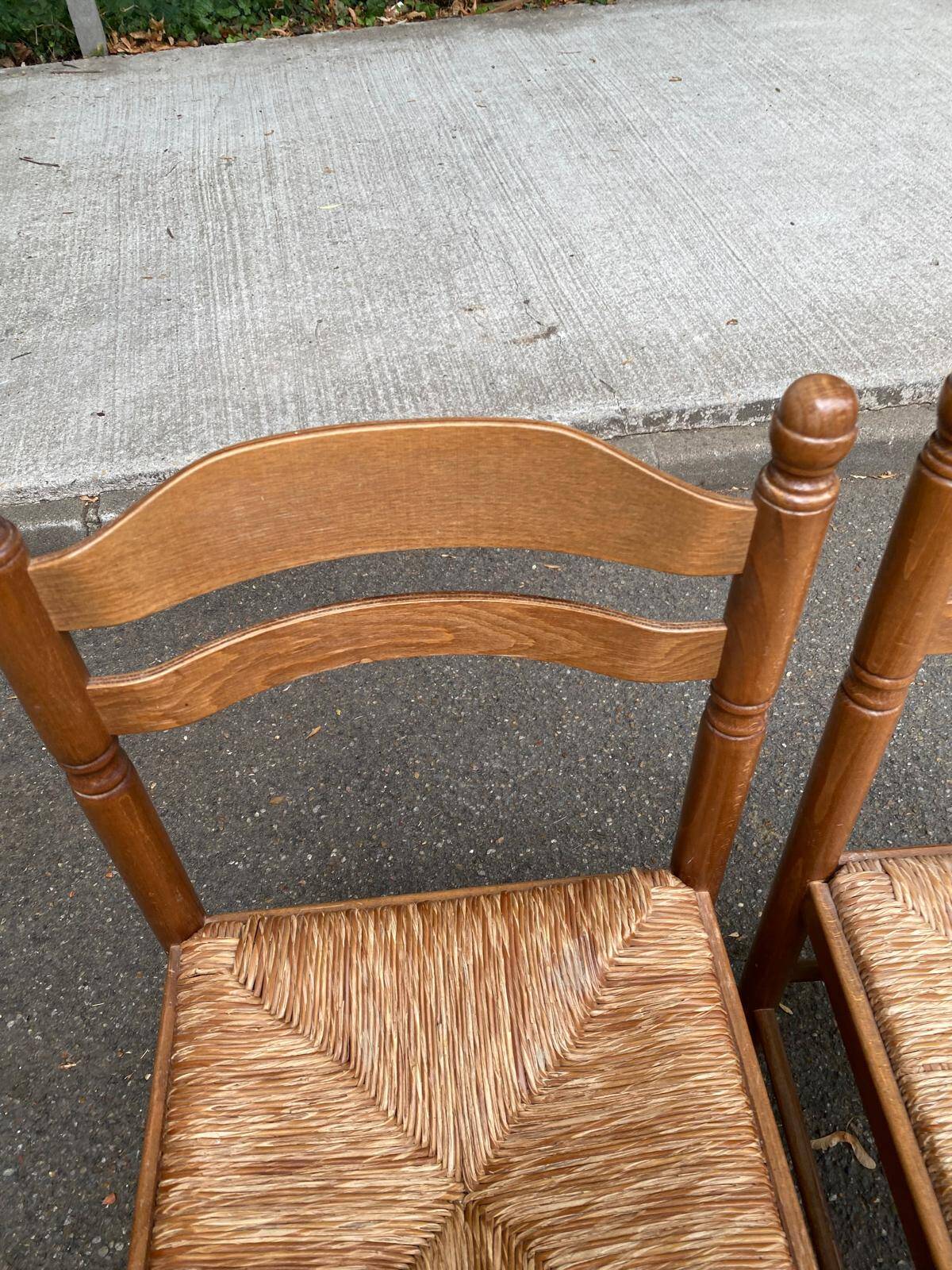 4 solid wood kitchen chairs with straw seats in a country farmhouse style.