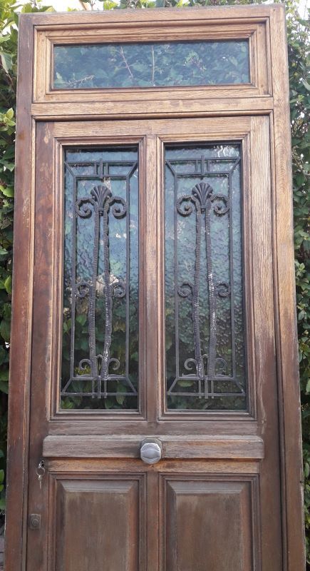 Oak entrance door and its frame and transom, wrought iron gates