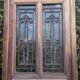 Oak entrance door and its frame and transom, wrought iron gates
