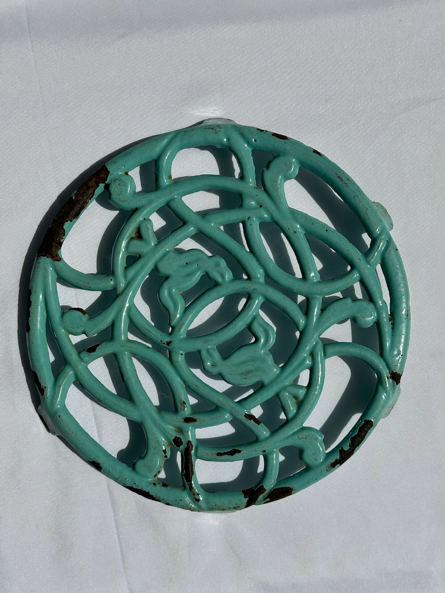 Enamelled cast iron trivet in blue with wrought iron decoration.