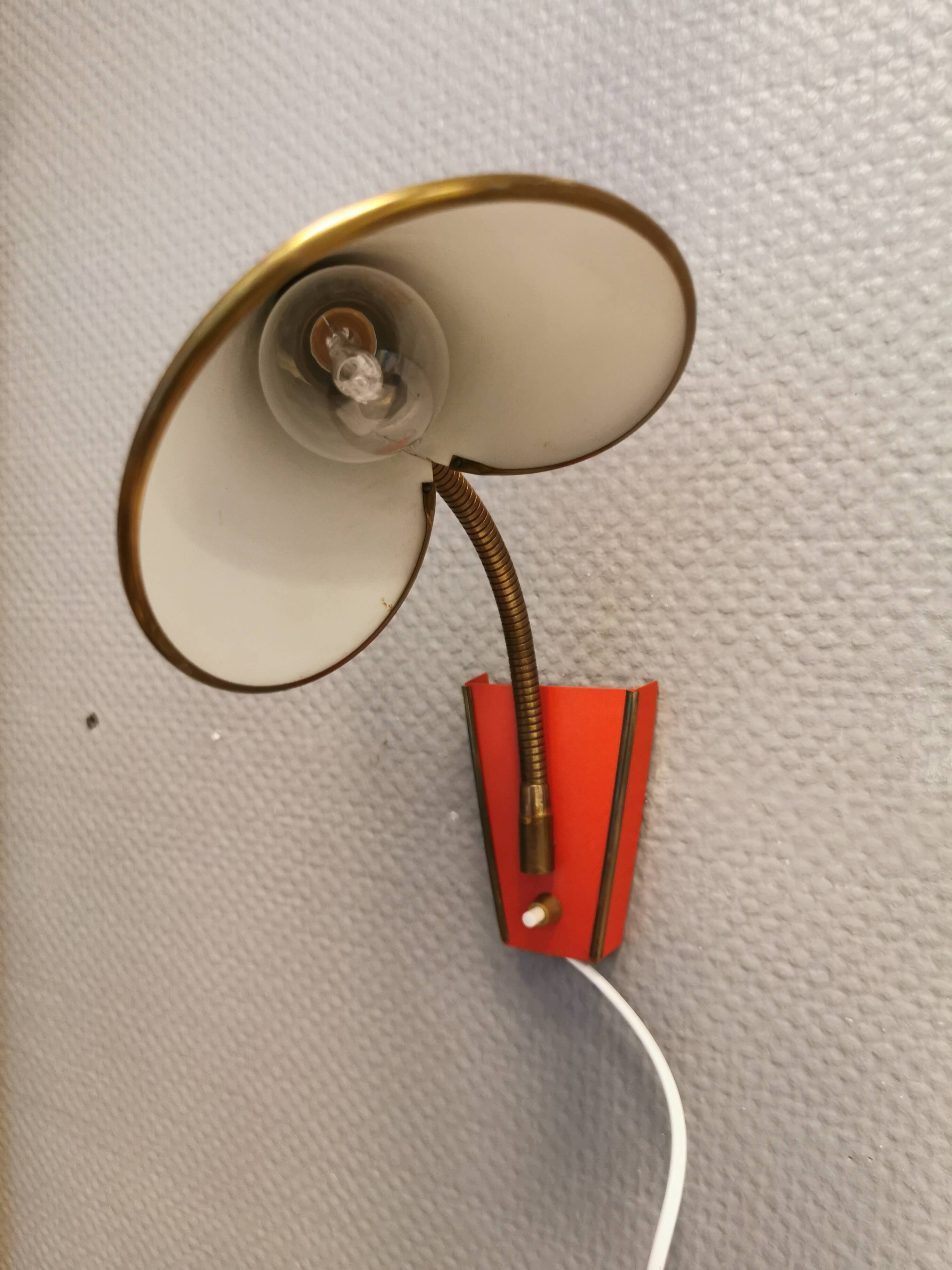 Danish red lacquered wall light with brass details. Estimated 1980s