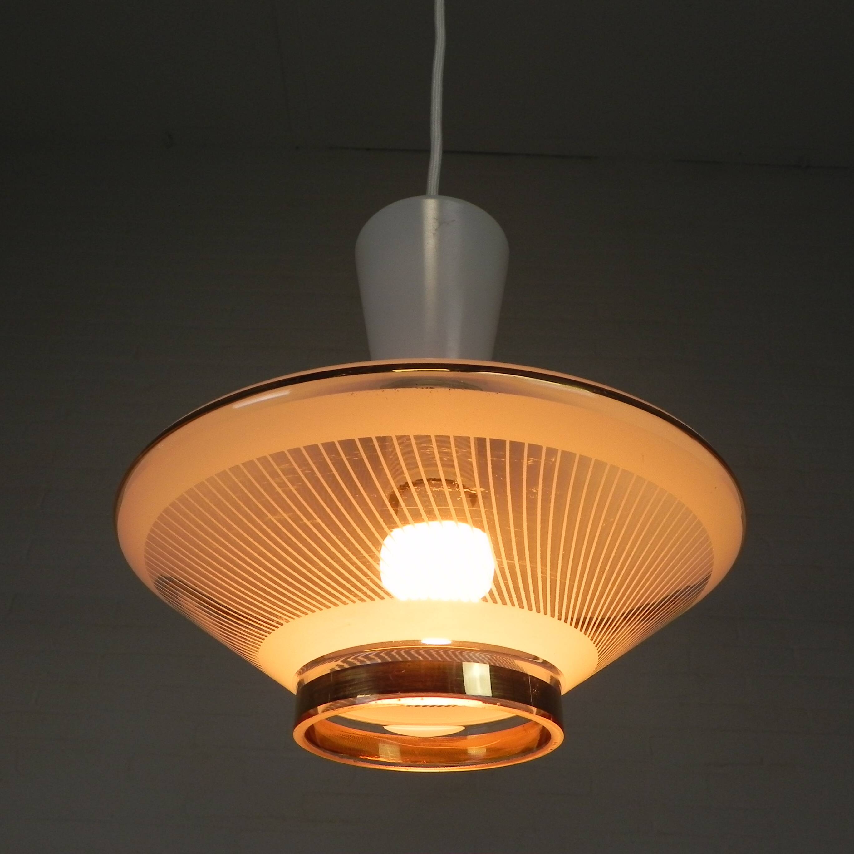 UFO-shaped pendant lamp with white glass on top and clear glass with white