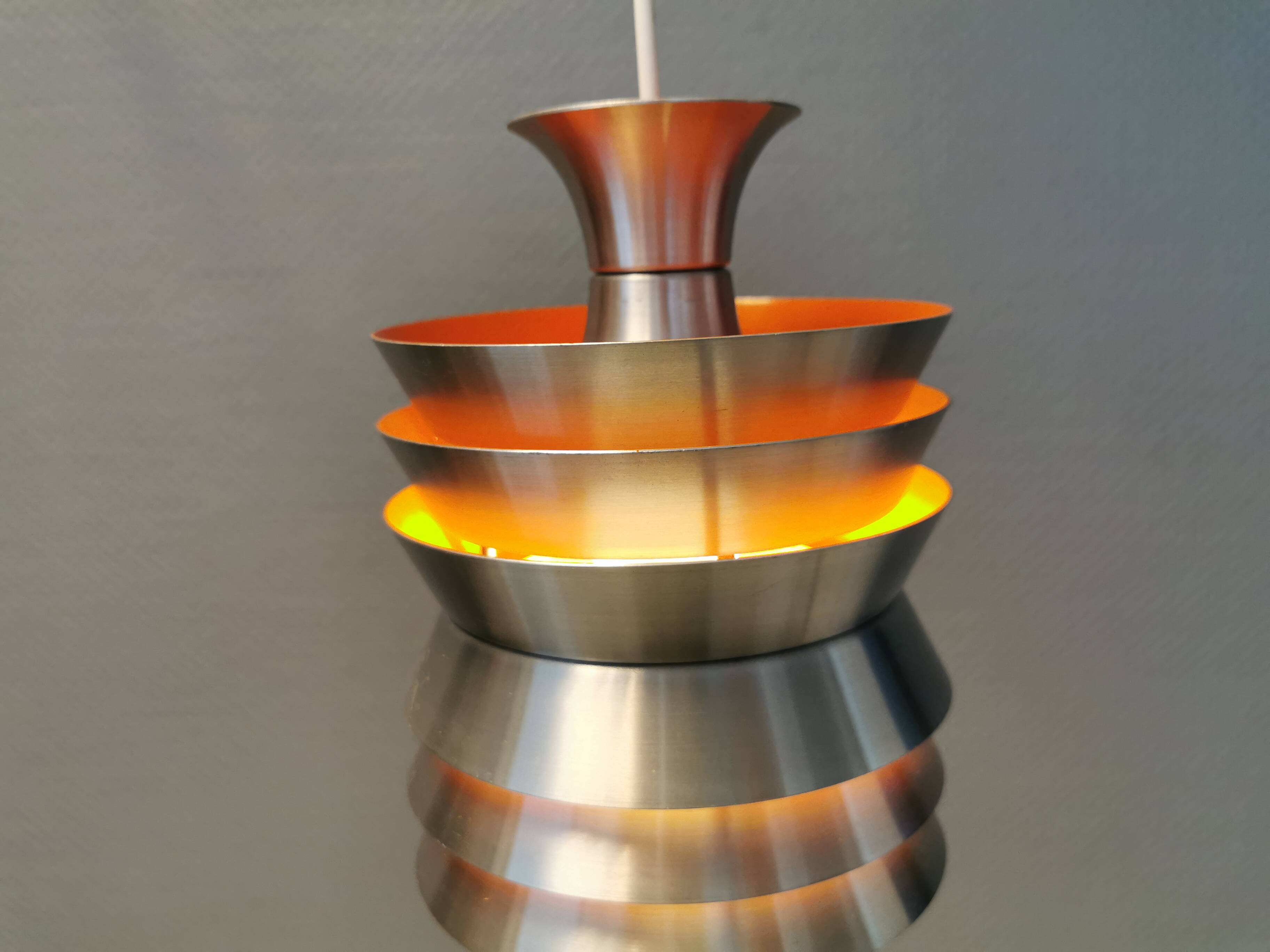 Danish/Swedish hanging lamp, in silver-coloured aluminium with orange interior paint.