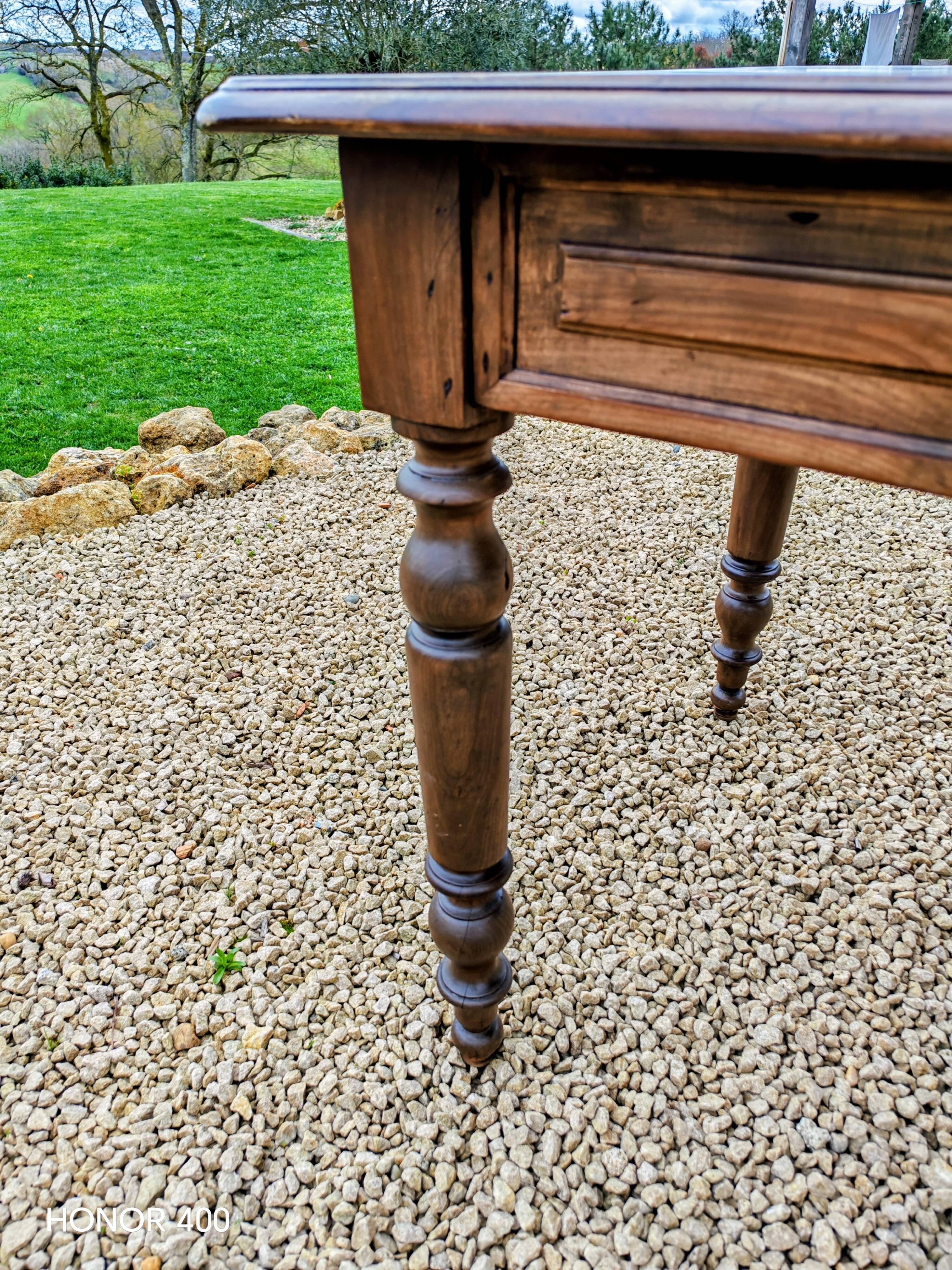 Old French farmhouse table in walnut with turned legs.