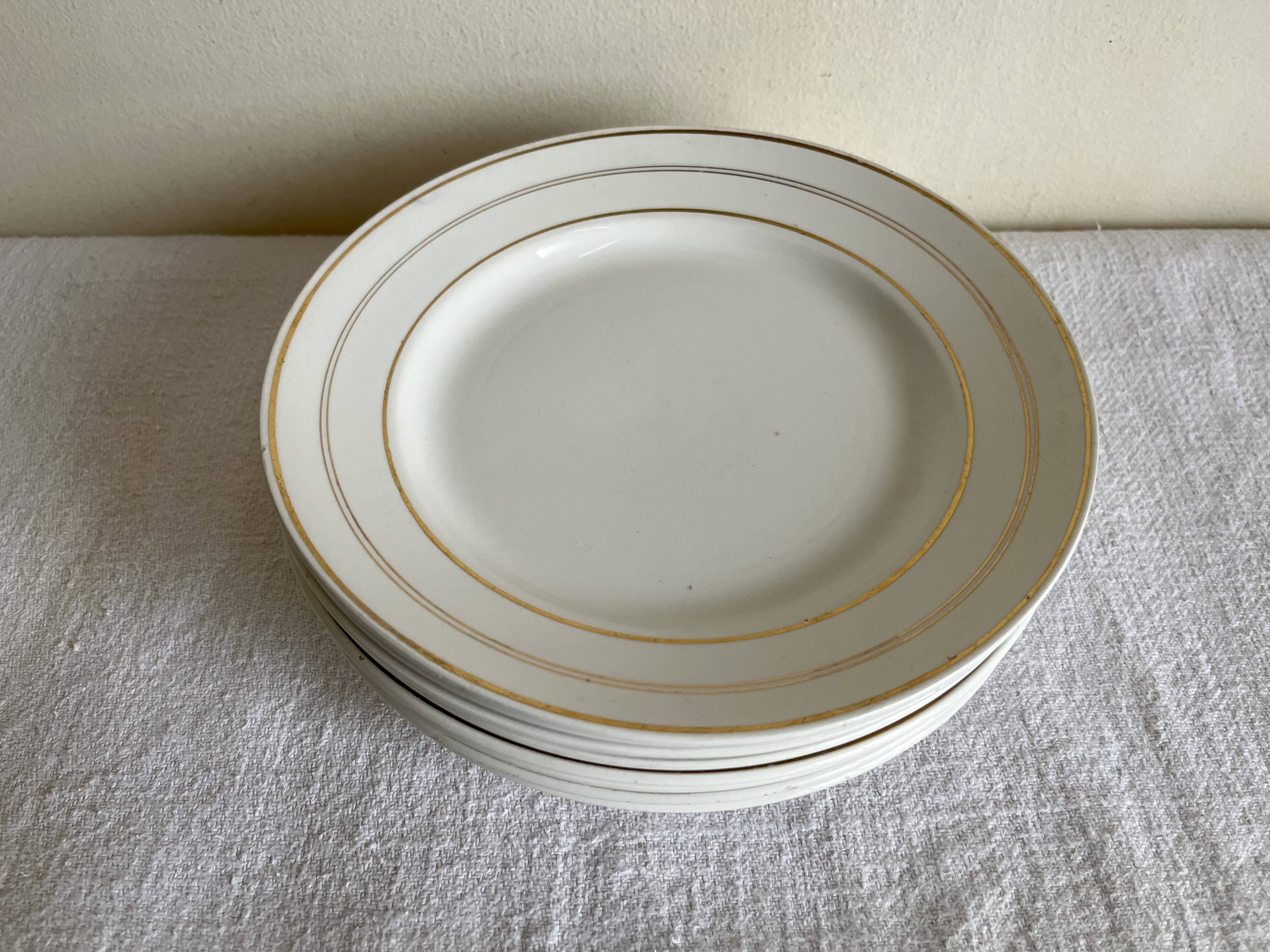 Set of 8 modernist flat plates in fine earthenware with pure gold trim, 1930.