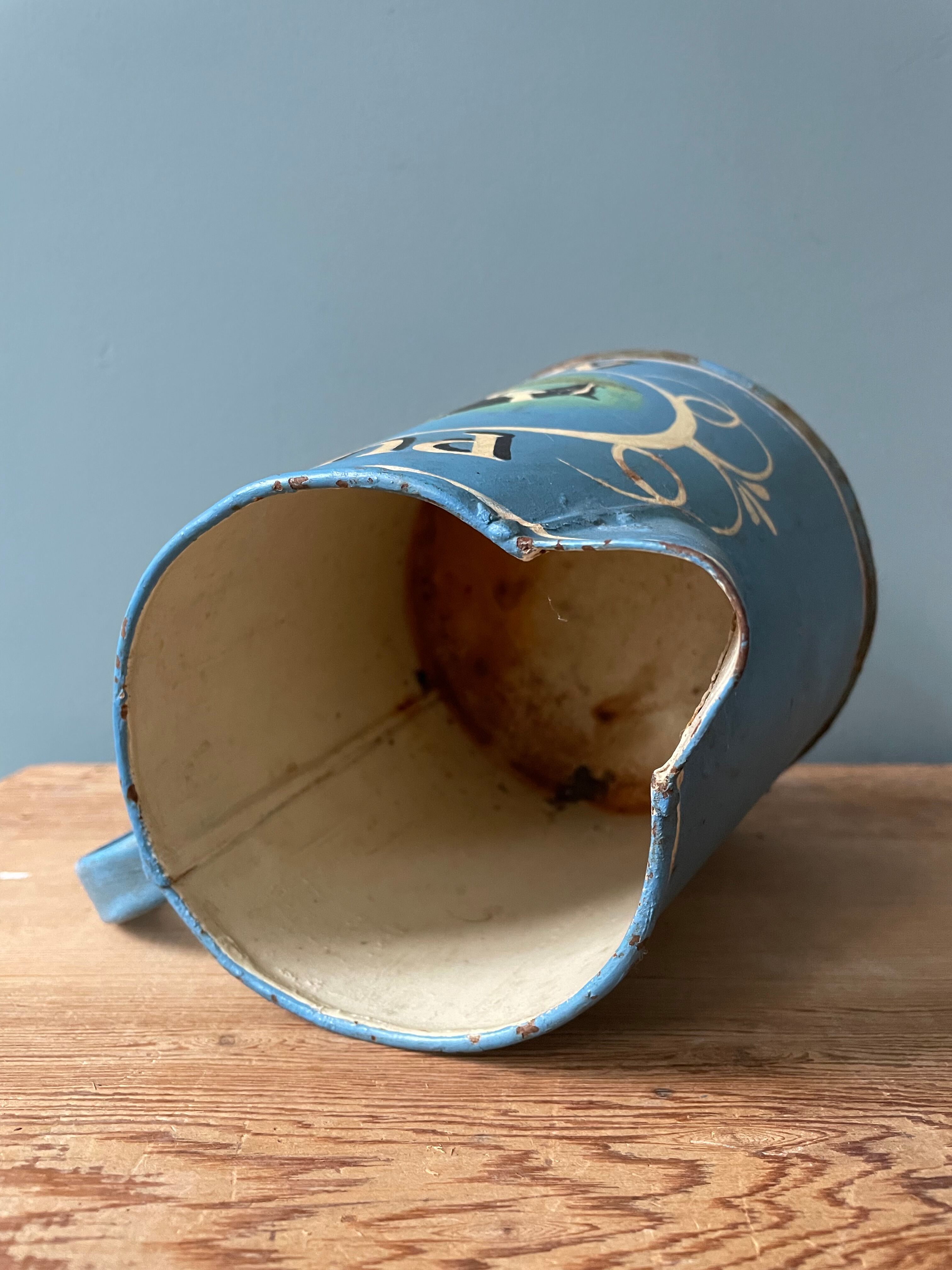 Old painted sheet metal jug or milk jug