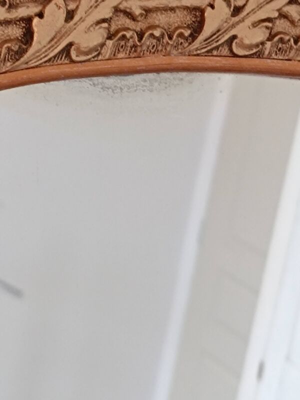 Miroir ovale au cadre doré et travaillé