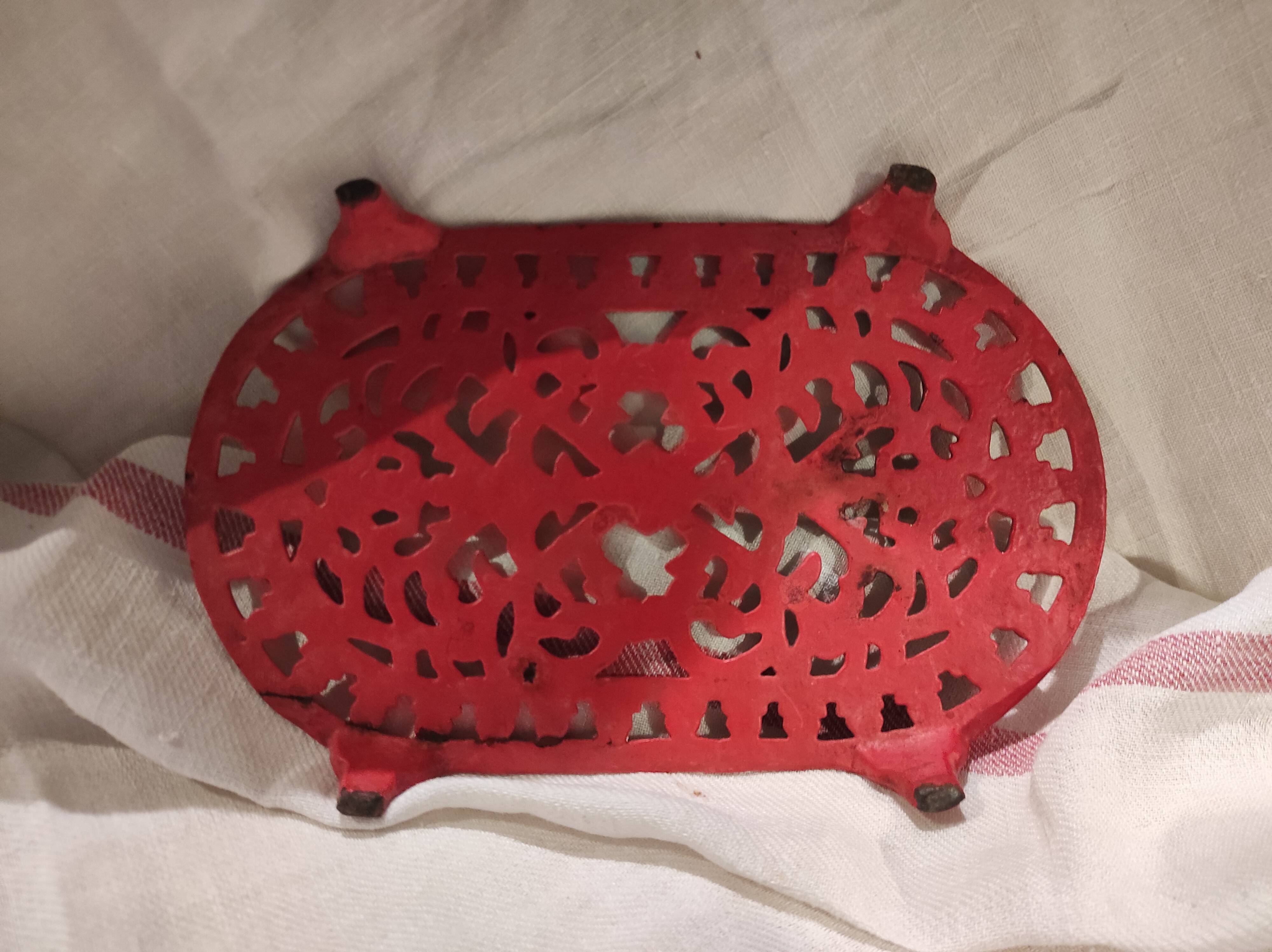 Vintage oval dark coral pink cast iron trivet