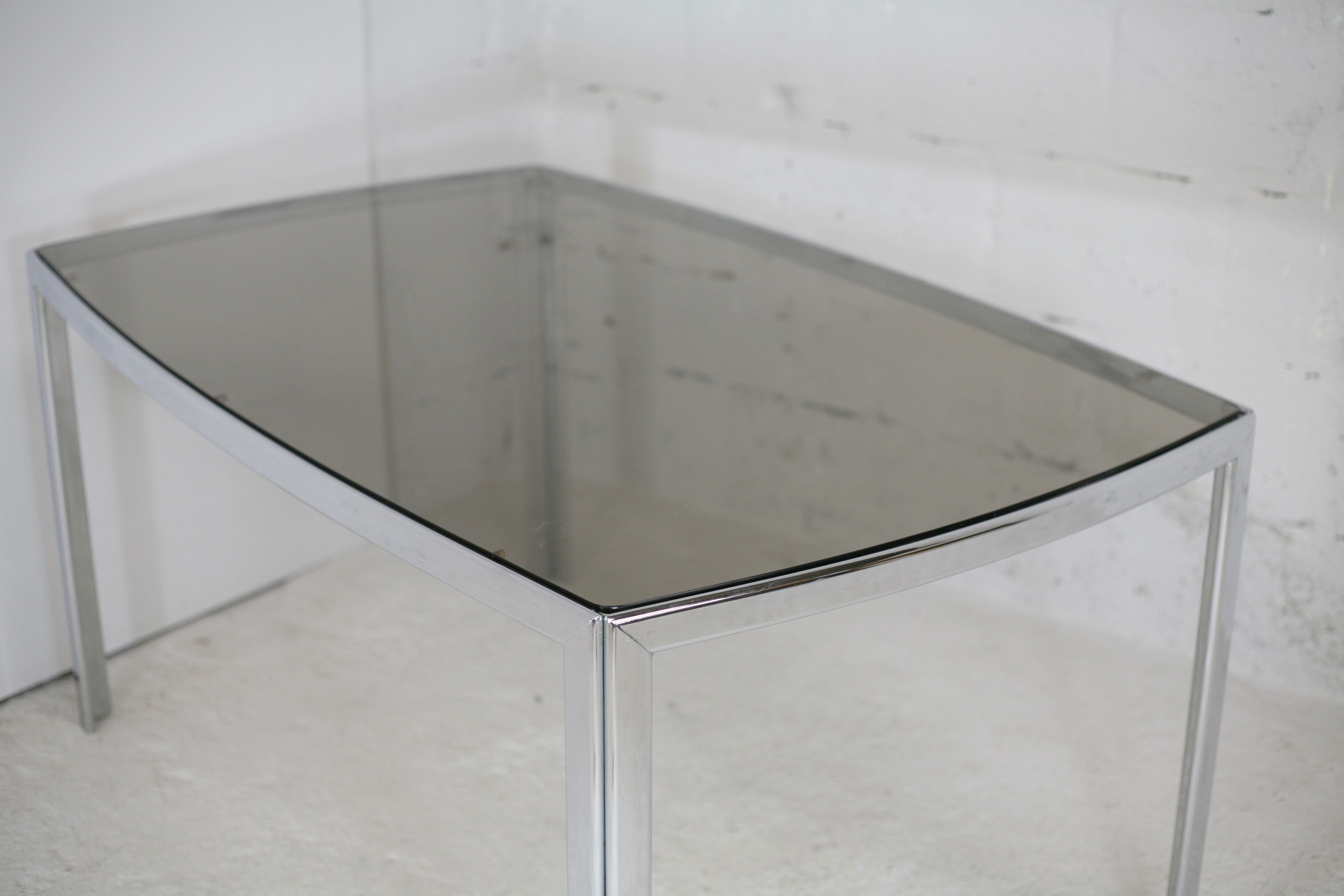 Living table. chrome metal, curved smoked glass slab, france, circa 1970.