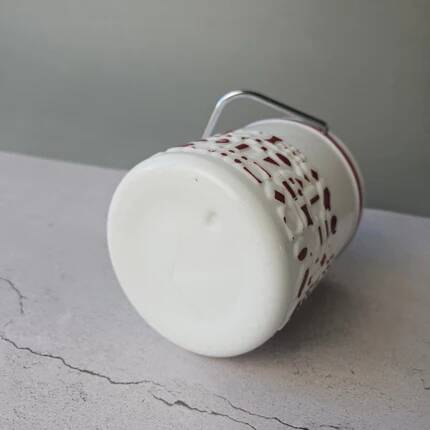 Vintage white opaline ice bucket with red patterns.