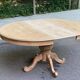 Extendable round dining table with central art deco leg, renovated in raw wood