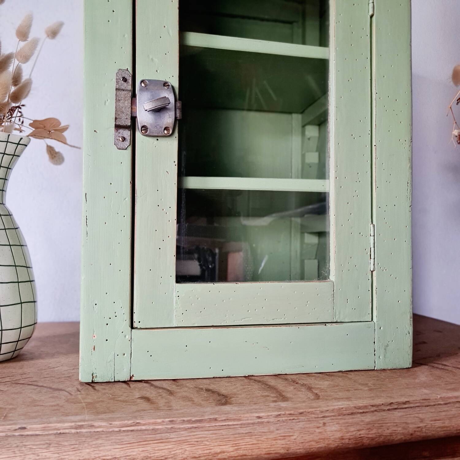 Small glass cabinet in green colour.
