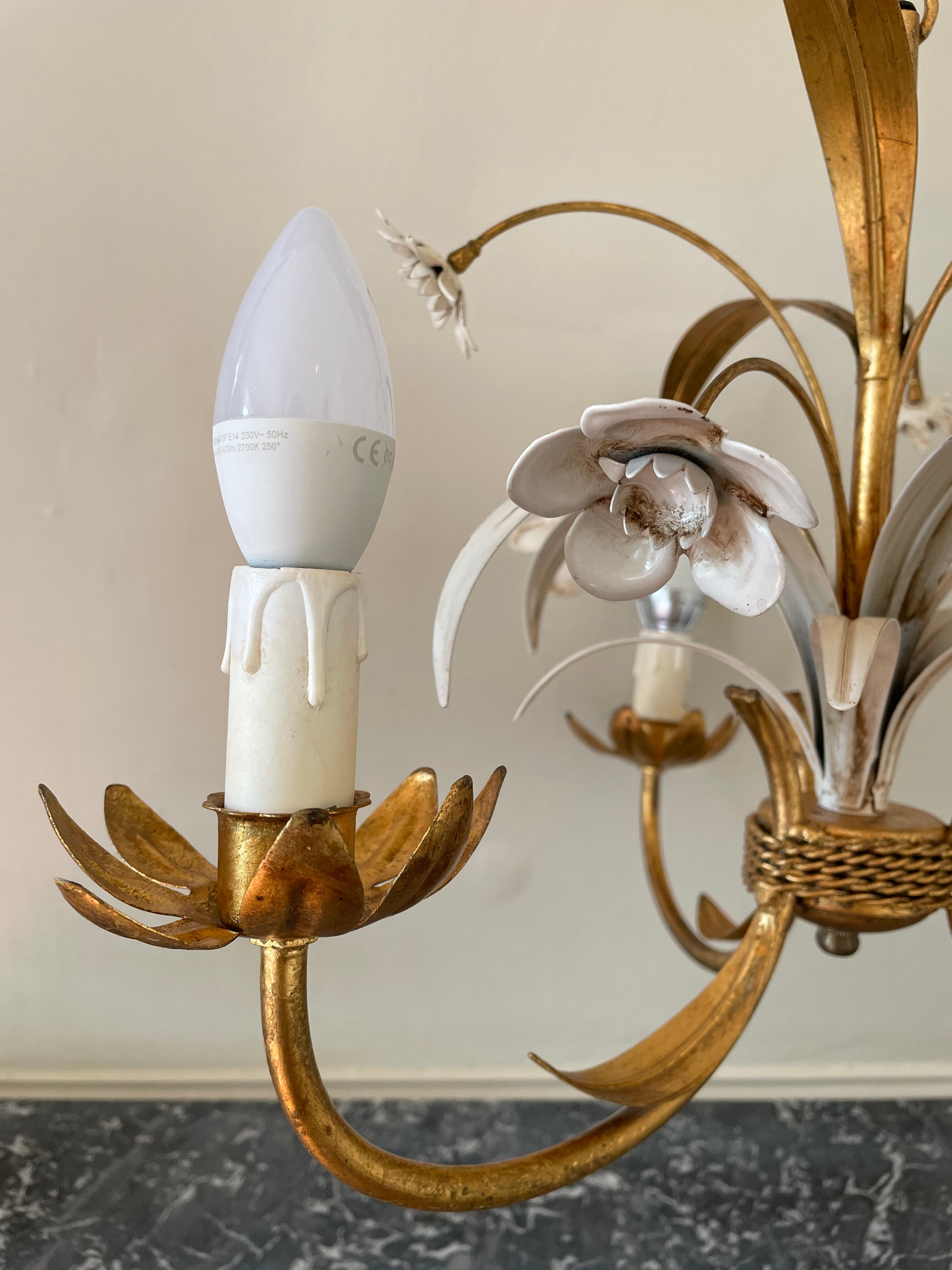 Golden metal chandelier decorated with flowers