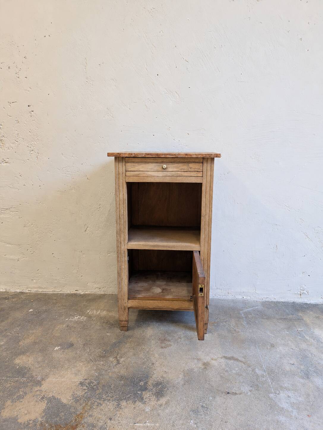Antique wooden bedside table with a pink/orange marble top.