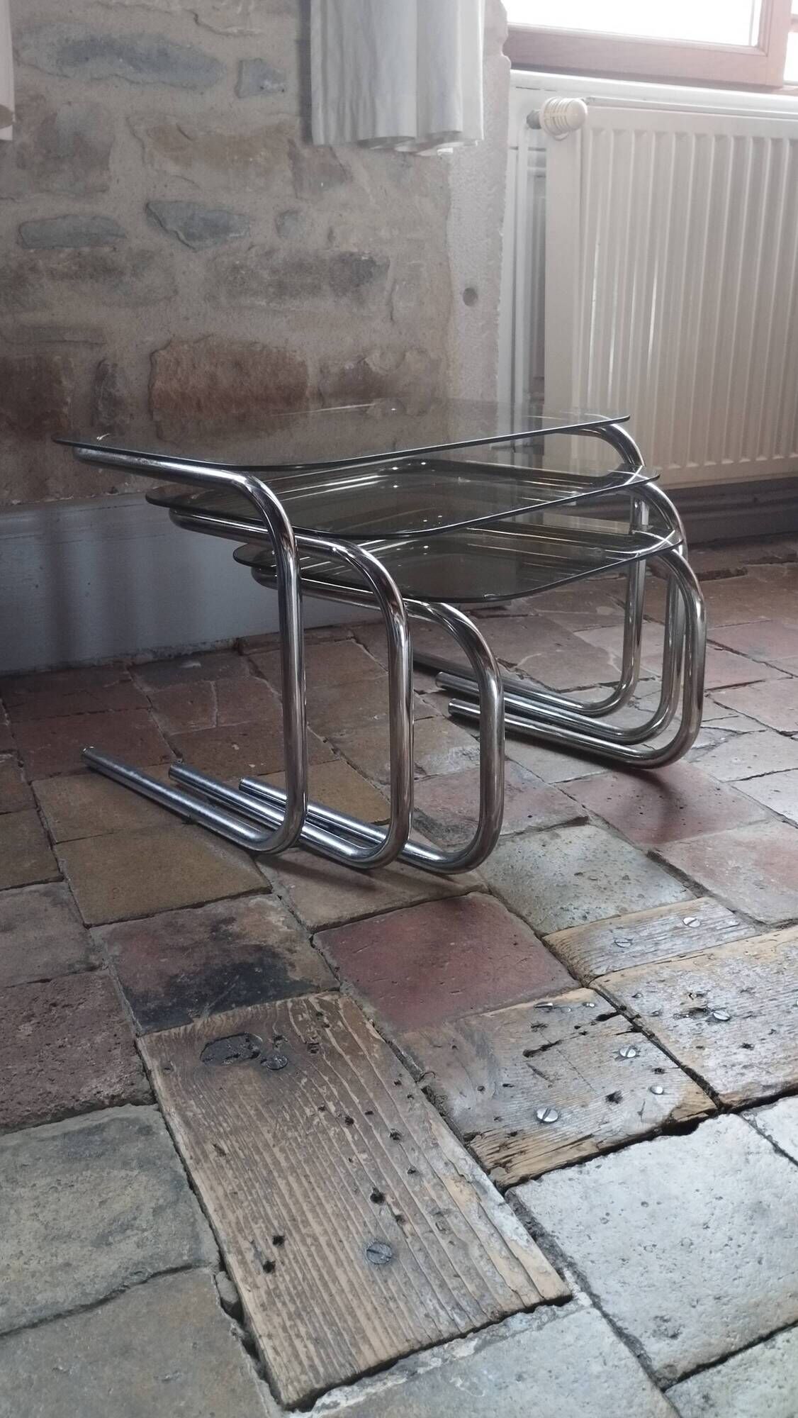 Nest of tables in glass and chrome steel.