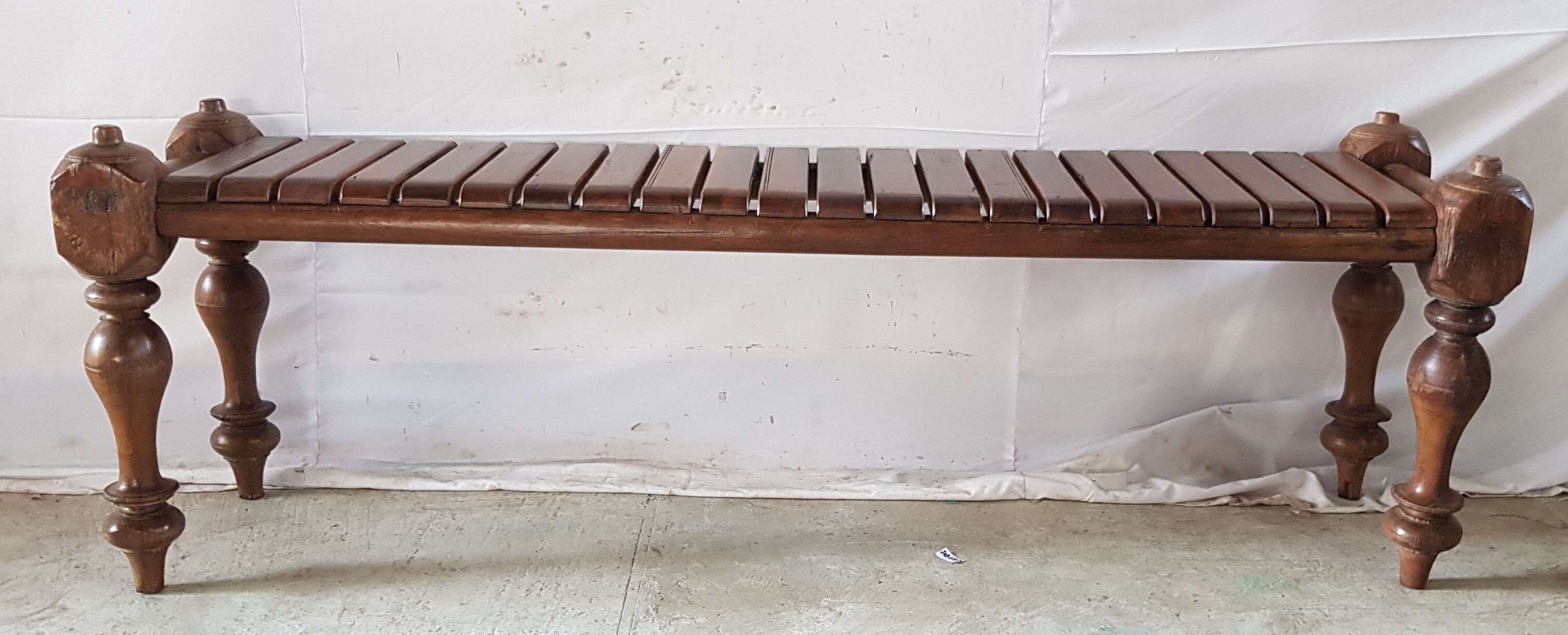 Bench with slats and feet of charpoy beds in teak