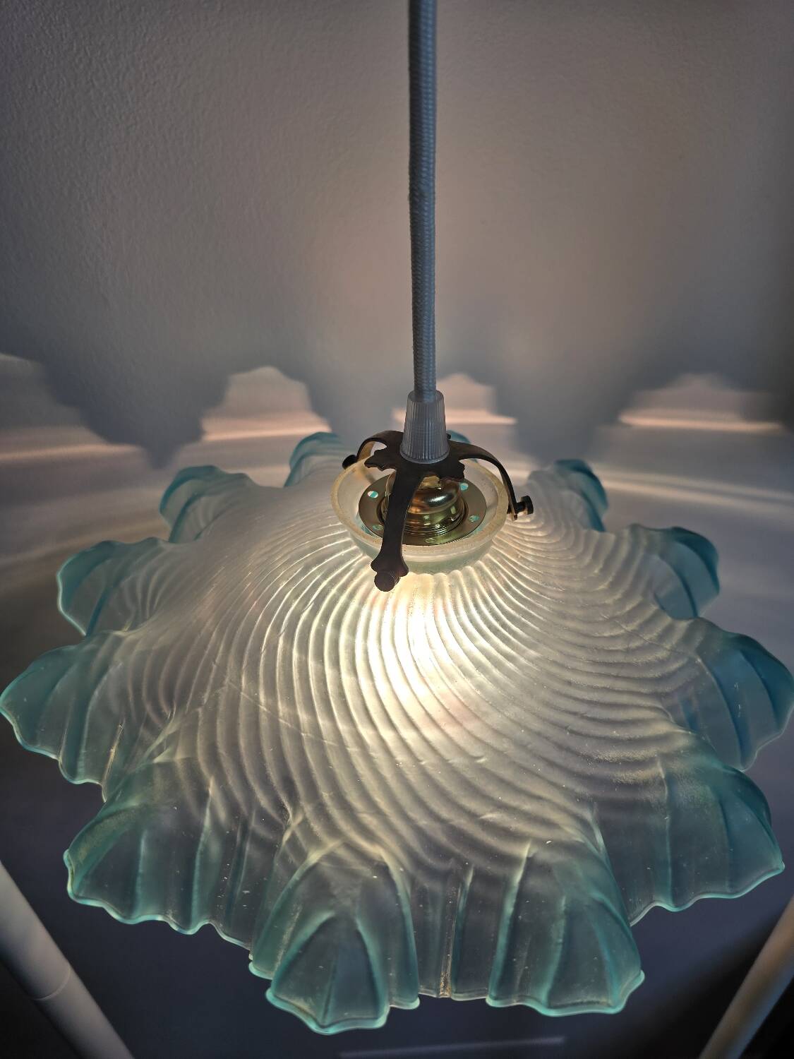 Suspension lampshade with scalloped edges in blue and its interior decoration.