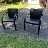2 black cantilever armchairs
