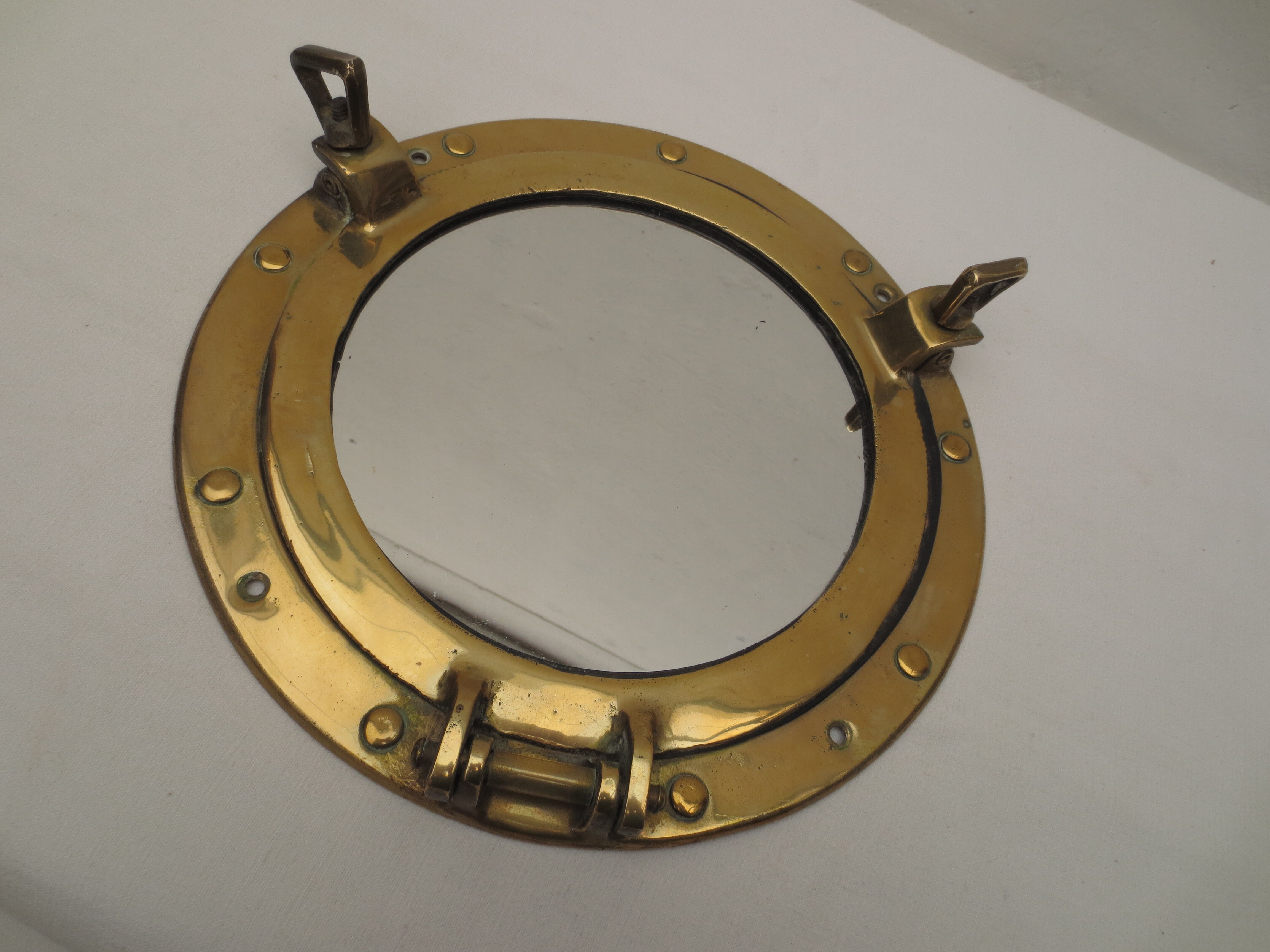 Mirror integrated into a brass navy porthole