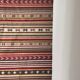 Large Indian rug with red, yellow, and white stripes and geometric fringes.