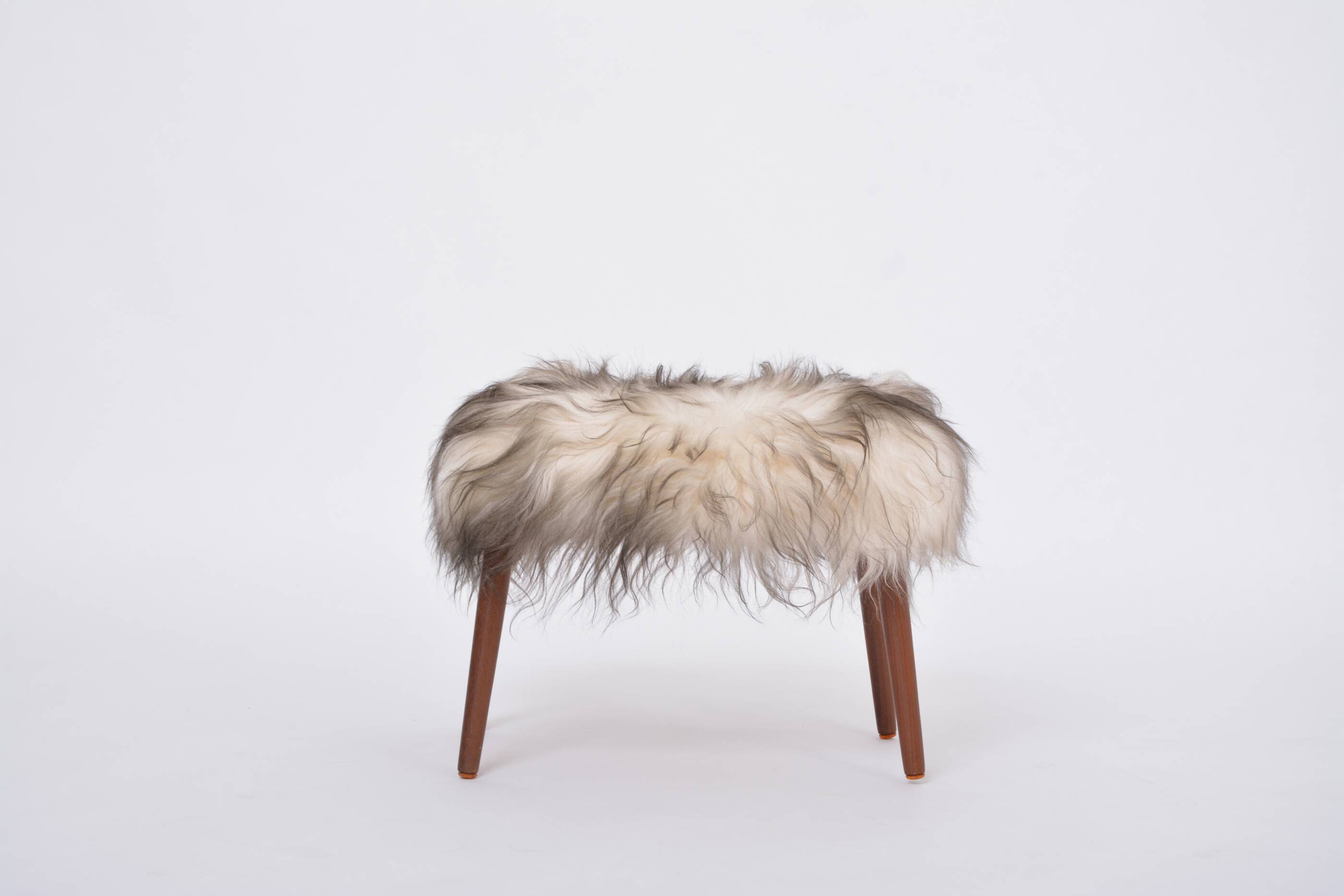 Danish Mid-century Modern stool reupholstered in white and black sheep skin