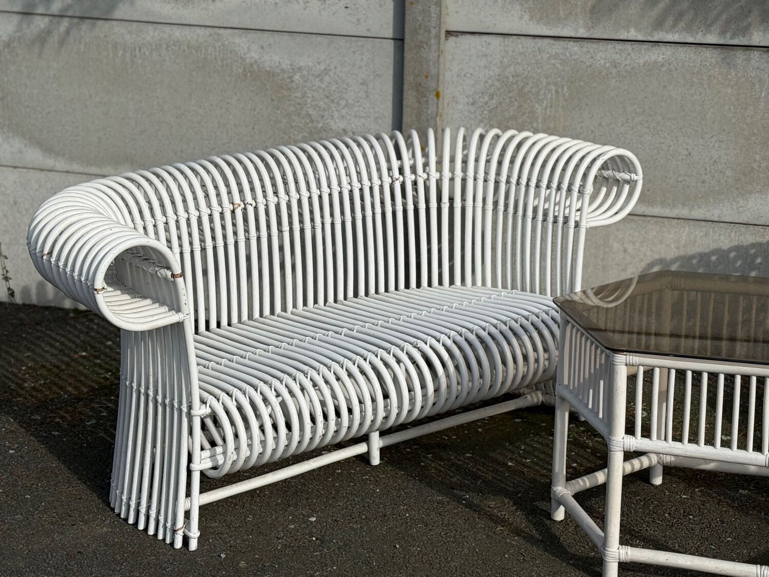 Rattan lounge with two two-seater sofas and a white coffee table.