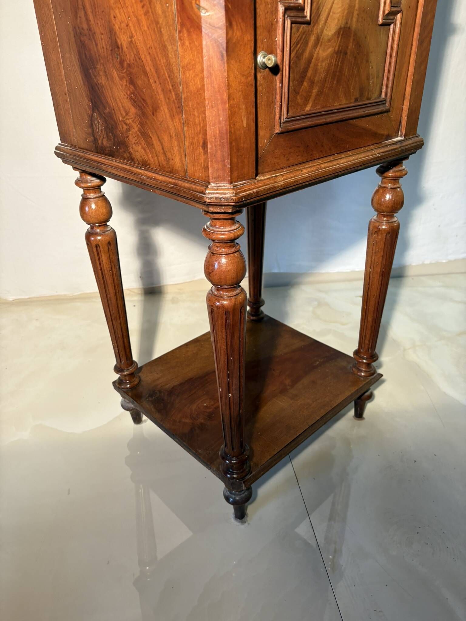 Antique wooden bedside table with turned legs.