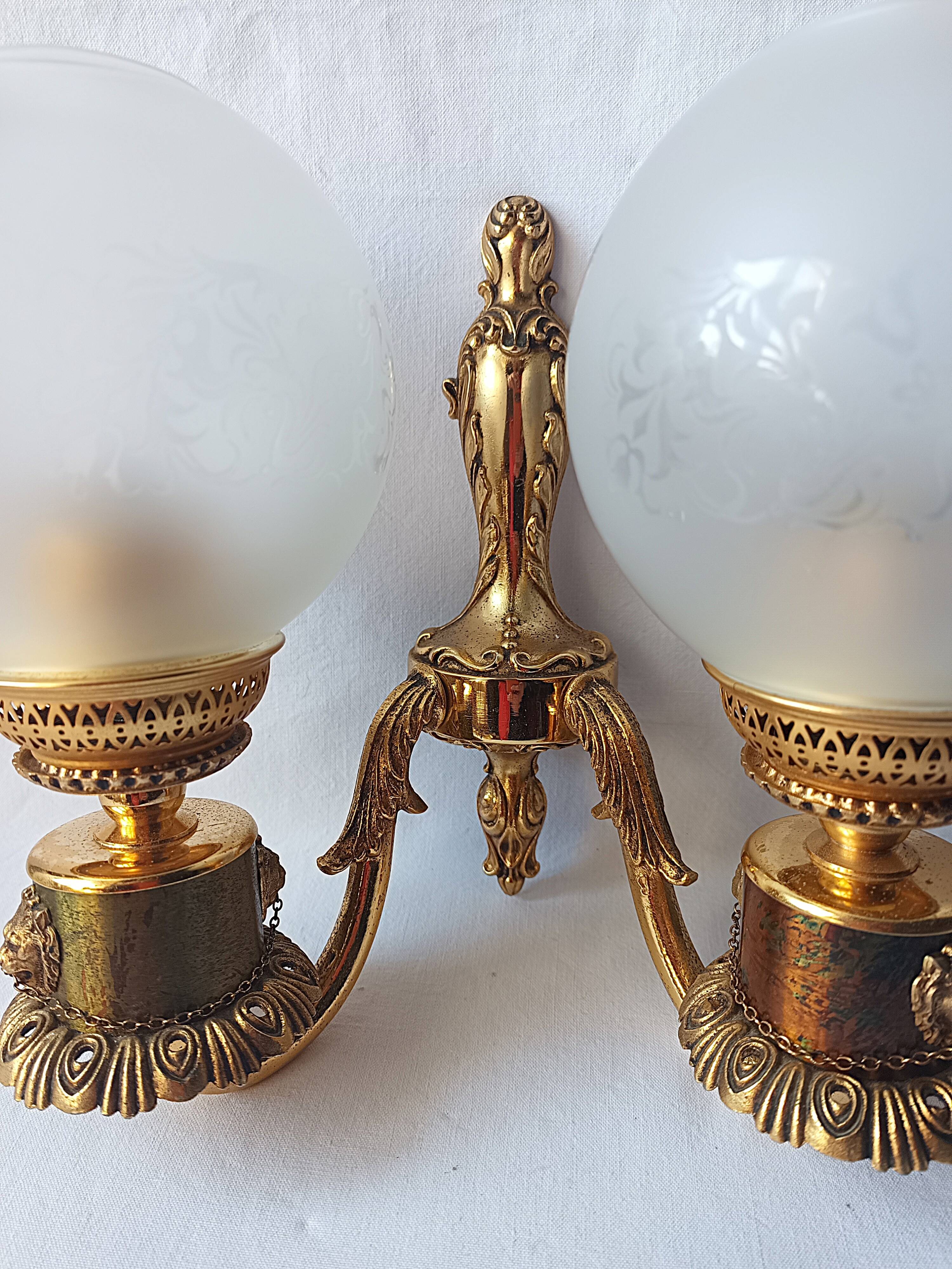 Wall lamp in gilded bronze with a lion's head and engraved globe.