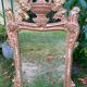 Mirror above a wooden and gilded stucco fireplace in the style of the 18th century.