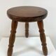 Old wooden tripod stool with ball feet