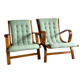 Set of 2 vintage lounge chairs with mint green cushions.