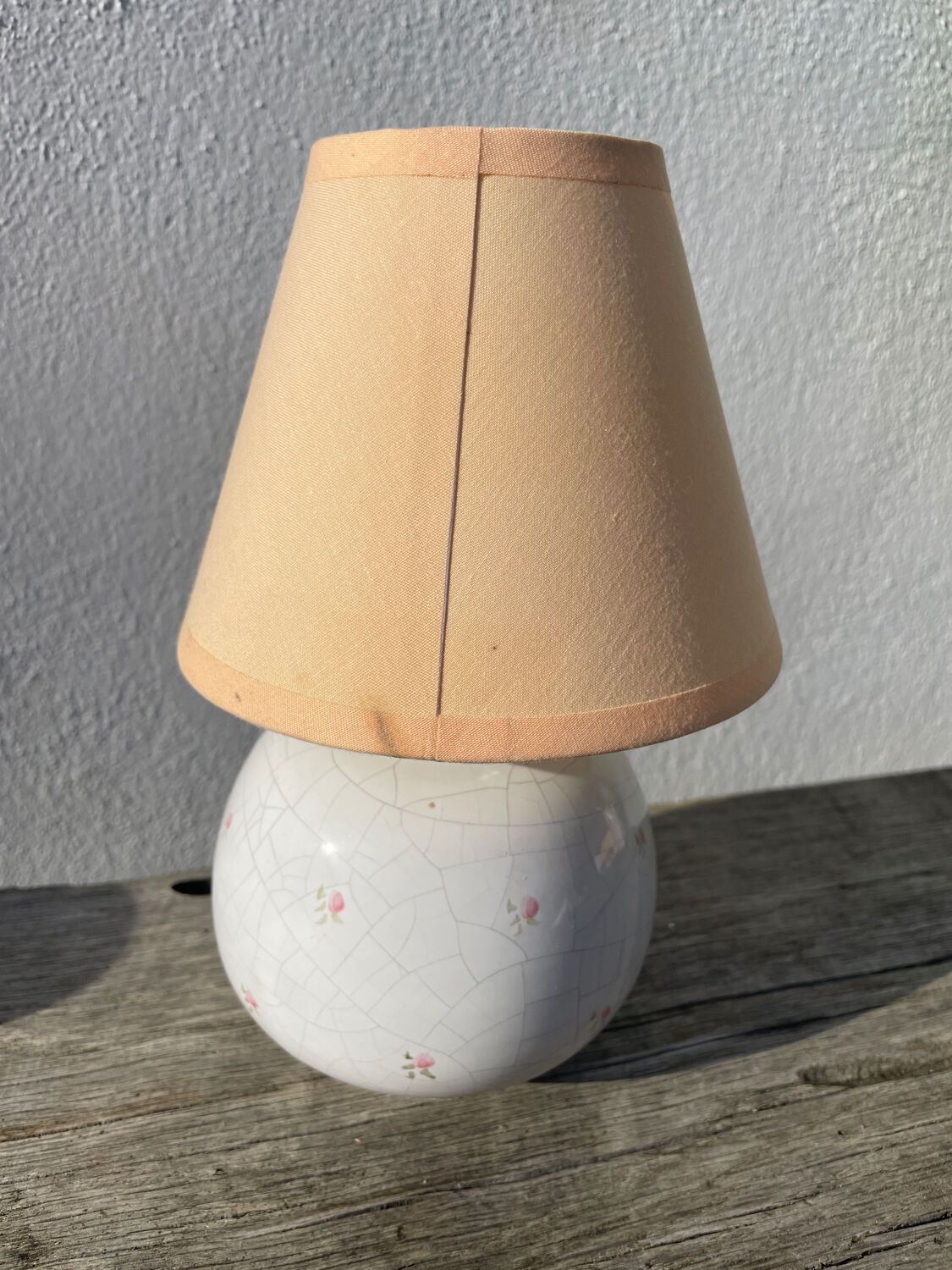 Small cracked white ceramic lamp with flowers.