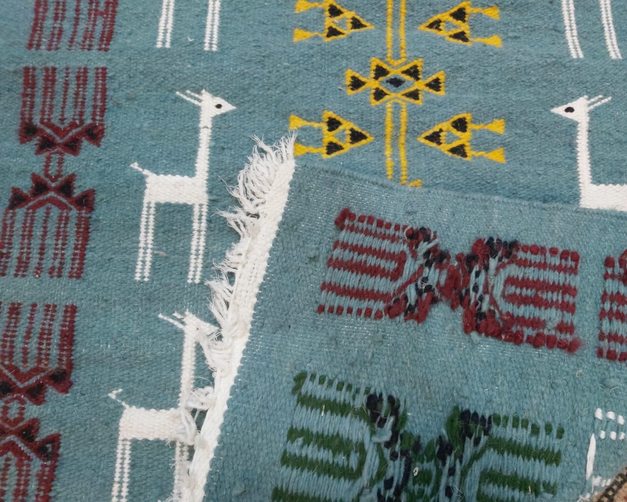 Blue carpet with gazelle patterns woven by hand